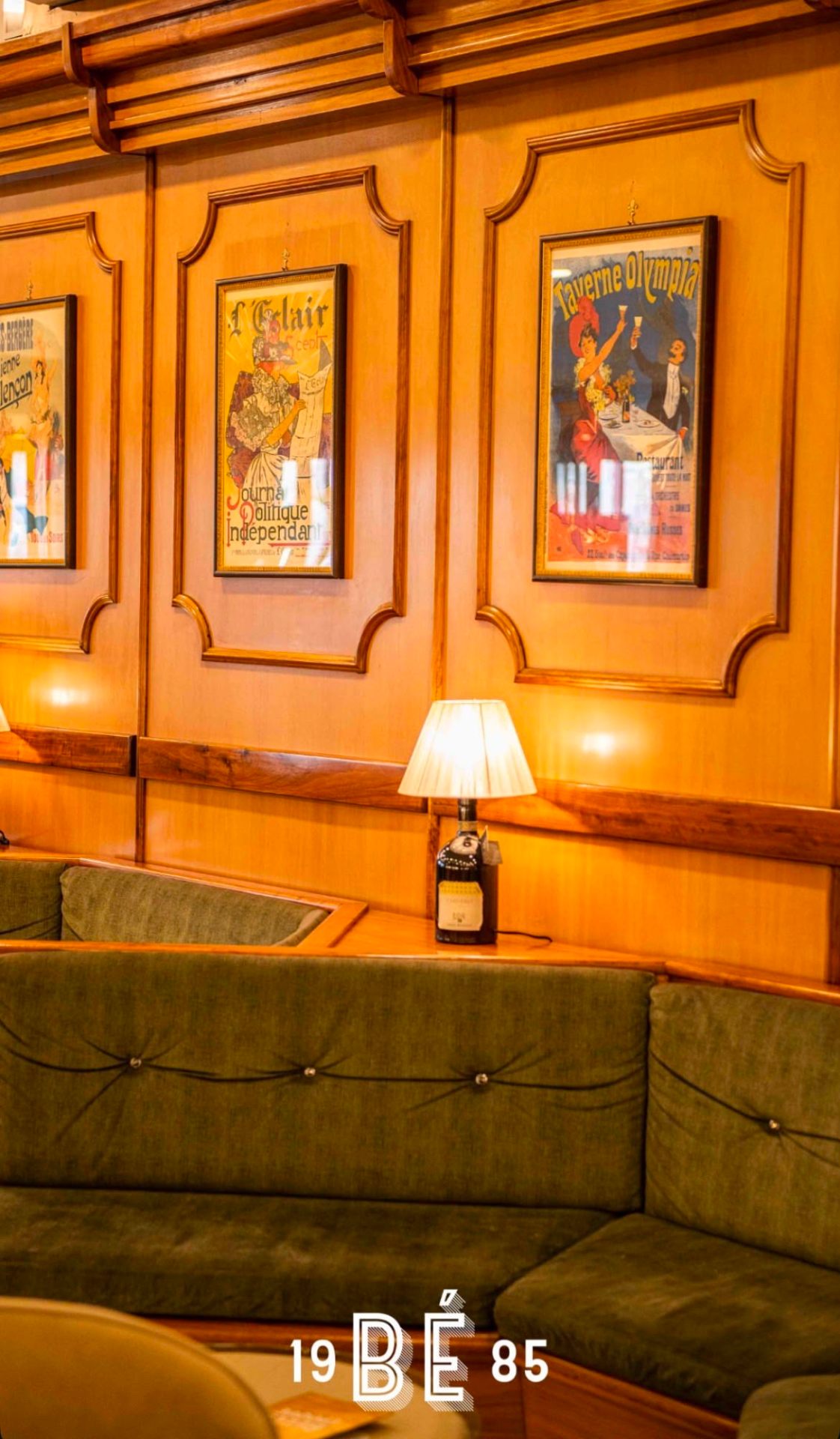 Interno di Belle Époque a Giugliano: boiserie, poster Belle Époque francesi e divani in velluto verde